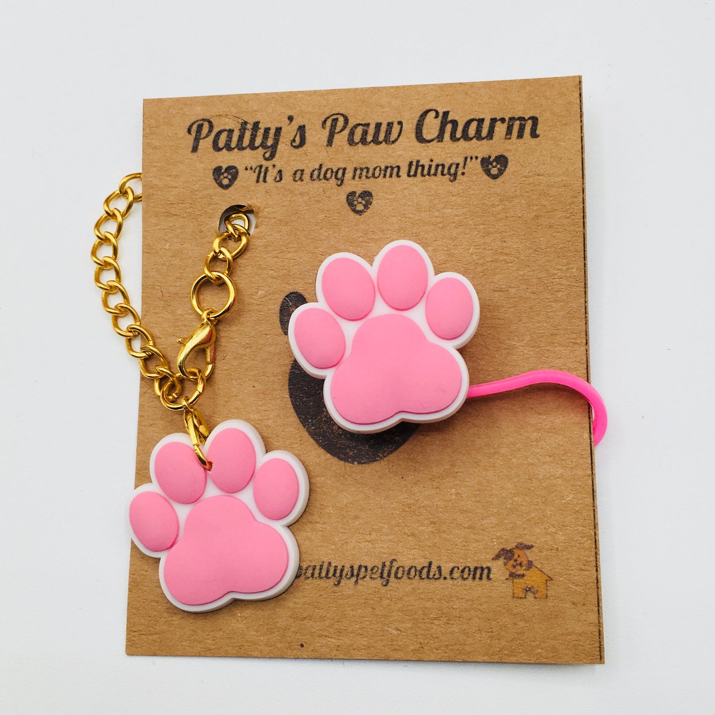 A pink silicone water bottle straw cap with a paw print design, displayed along a white background