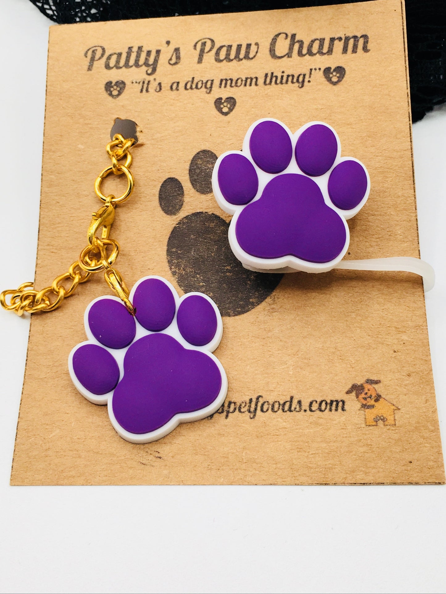 A purple silicone water bottle straw cap with a paw print design, displayed along a white background