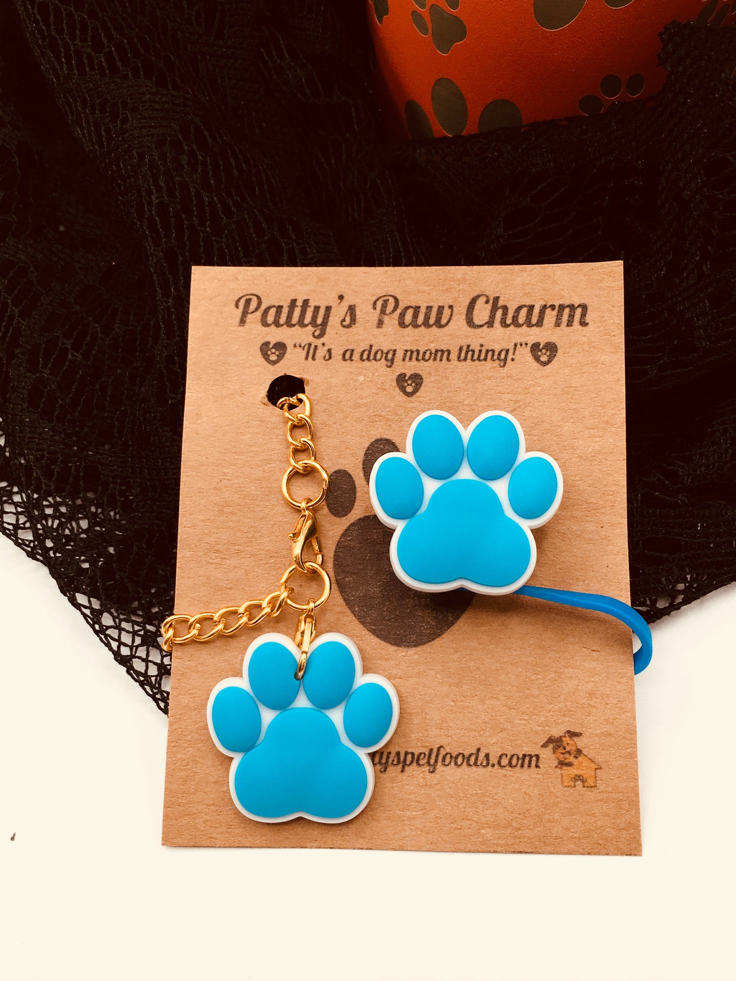 A blue silicone water bottle straw cap with a paw print design, displayed along a white background
